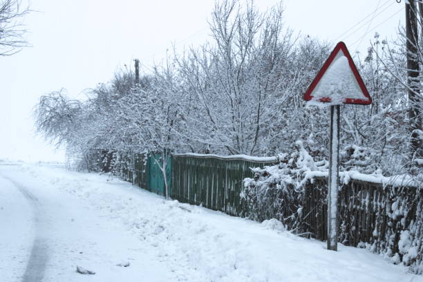 istock Snow covered road and trees. Road sign covered with snow. 1162831433