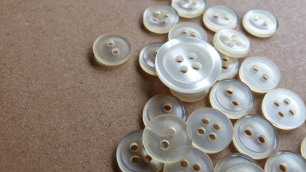 istock One big white button and lots of small white buttons on plain background with copy space 1162832808