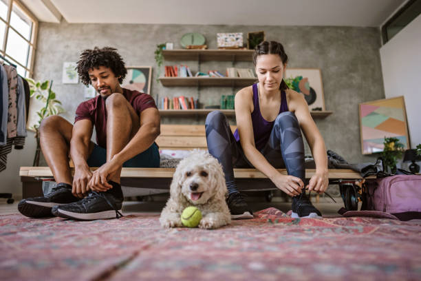 jeune couple multiethnique se préparant pour le jogging - basket making photos et images de collection