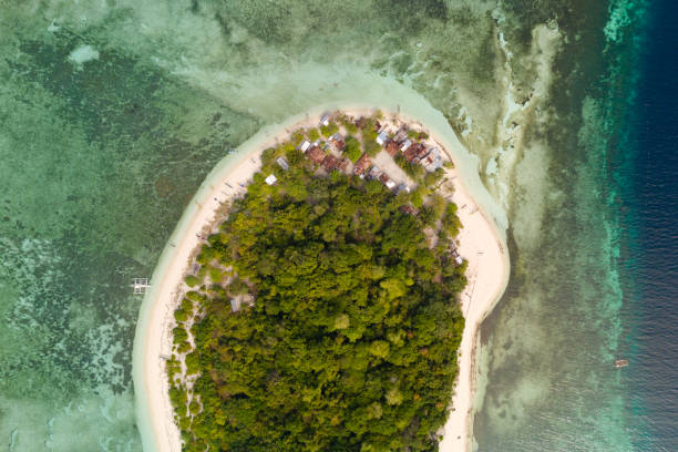 istock Round tropical island with white sandy beach, top view.A small island surrounded by azure water and coral reefs, a top view 1162836707