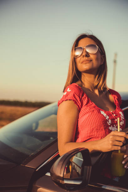 istock Young woman enjoying sunshine while making a break from driving 1162839063