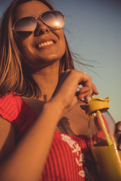 istock Smiling young woman watching summer sunset 1162839072