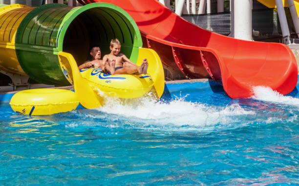 zweierfamilie reitet gemeinsam im aquapark - amusement park family water slide child stock-fotos und bilder