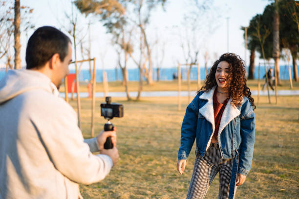 istock Young man shooting video for young woman 1162840712