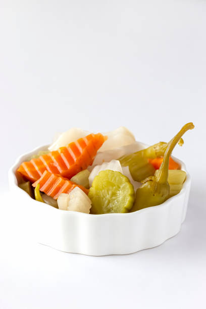 Assorted pickles vegetables carrot, chili, radish in white ceramic bowl. Top view. Isolated. Copy space. Isolate white background.