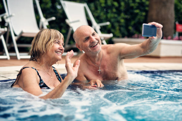 istock Happy senior couple enjoying swimming pool 1162840742
