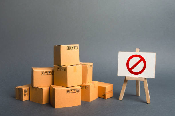 istock A stack pile cardboard boxes and a sign stand with red symbol NO. Restriction on the importation of goods, proprietary for business. Embargo, trade wars. Inability to sell products, ban on the import. 1162841710