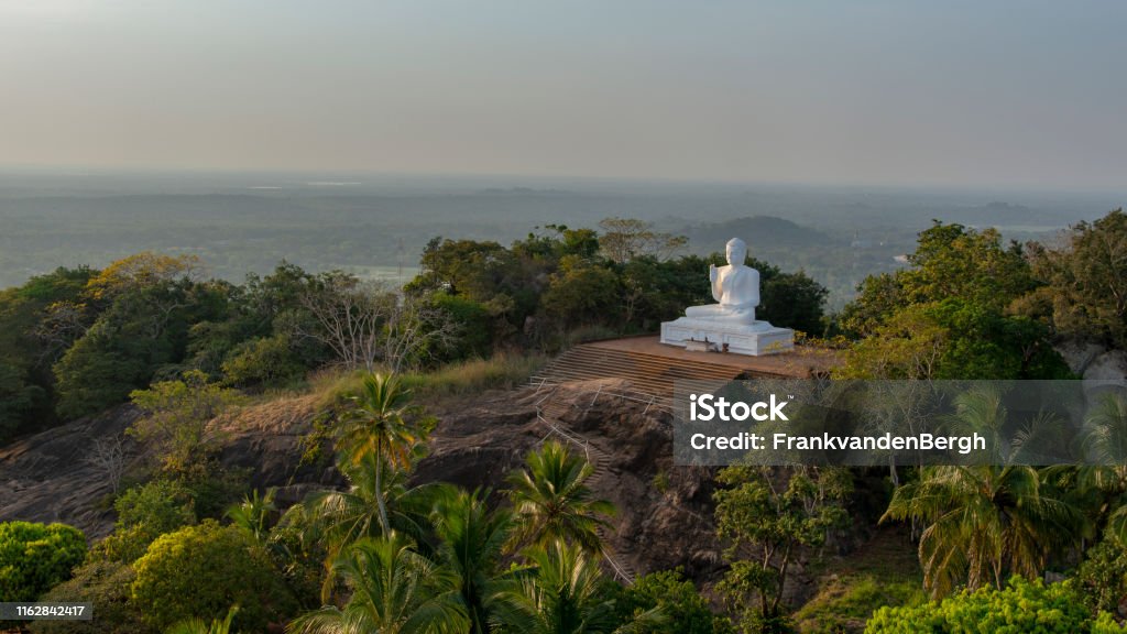 White Buddha Rainforest with a white Buddha statue at the pilgrimage site of Mihintale. Anuradhapura Stock Photo