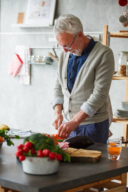 istock Senior man cutting vegetables for a delicious meal 1162842597