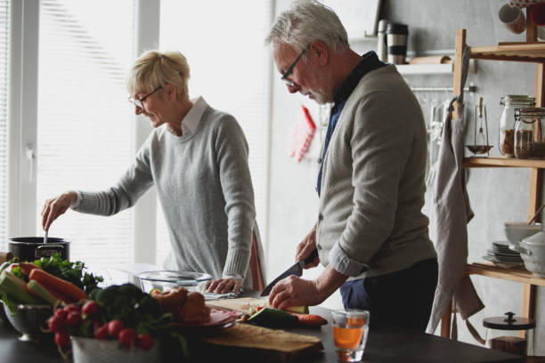 istock Cheerful senior married couple preparing lunch in the kitchen together 1162842607