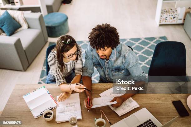 Multiethnic Couple Planning Their Home Budget Stock Photo - Download Image Now - Savings, Home Finances, Domestic Life