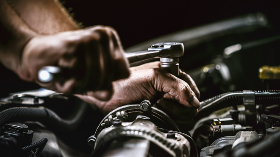 Mecánico de automóviles trabajando en el motor del coche en el garaje mecánico. Servicio de reparación. auténtico tiro de primer plano photo