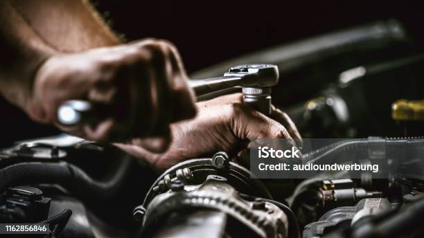 Auto Mechanic Working On Car Engine In Mechanics Garage Repair Service Authentic Closeup Shot Stock Photo - Download Image Now