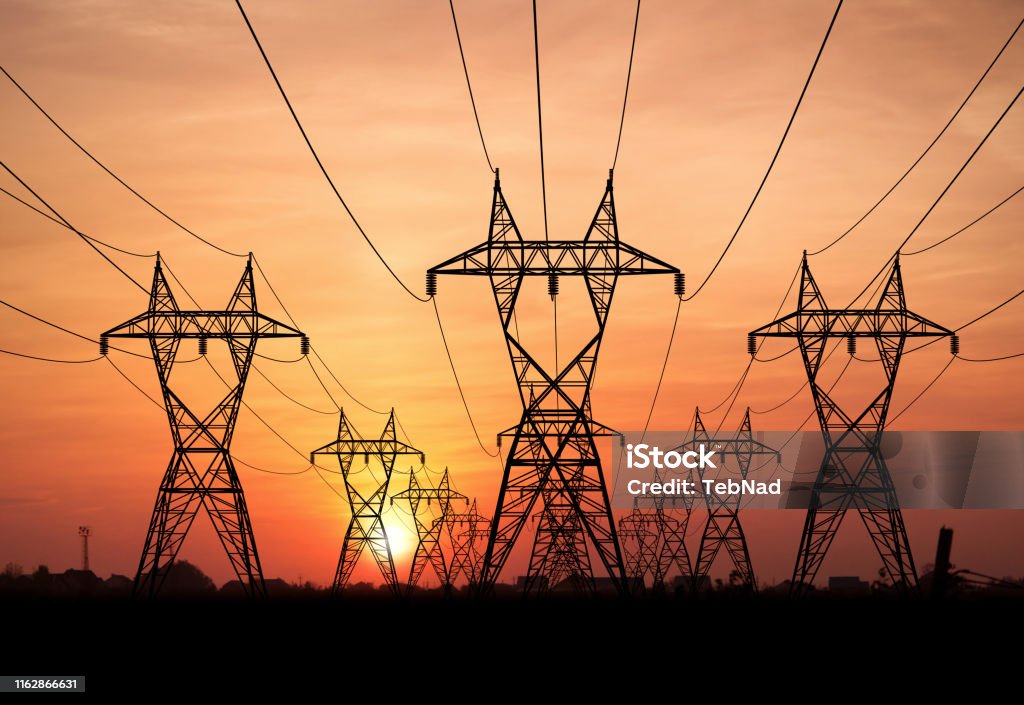 Power lines Electricity Pylons at sunset on background Fuel and Power Generation Stock Photo