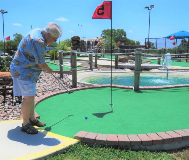 hombre mayor jugando mini golf - practicing golf putting golf flag fotografías e imágenes de stock