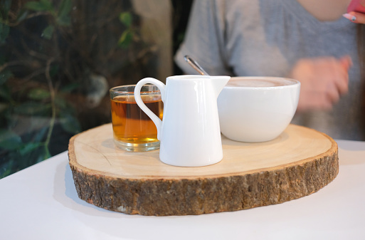 Close up set of hot drink on wooden tray on dining table in cafe