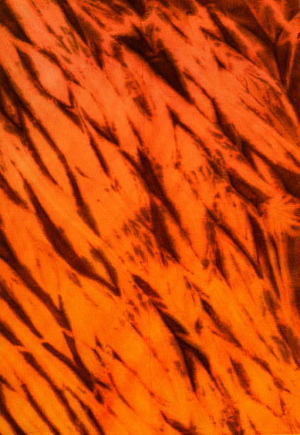 istock Abstract hand painted orange shibori fabric background with irregular stripes 1162876229