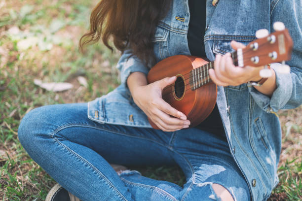 istock A woman sitting and playing ukulele 1162881660