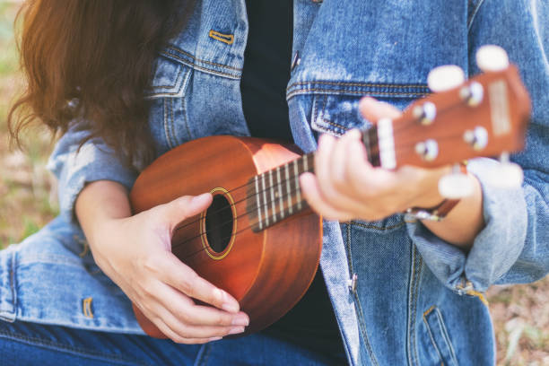 istock A woman sitting and playing ukulele 1162882181