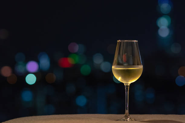 istock A glass with white wine puts on sofa with colorful bokeh light. 1162882564