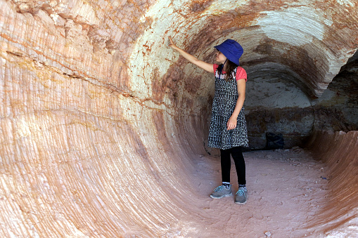 Australian girl (age 8-9) visiting in deserted opal mine in Coober Pedy, the Opal capital of the world, located in South Australia