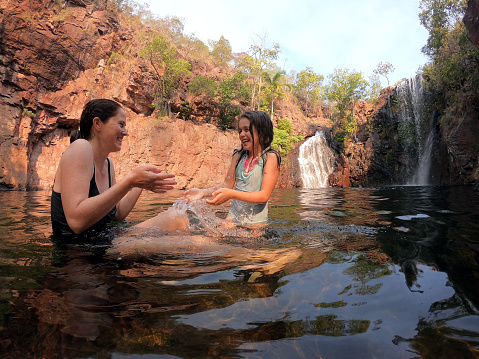 Australian mother and daughter having fun in Florence Falls in Litchfield National Park in the Northern Territory of Australia
