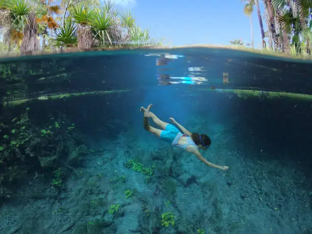 Australian woman diving in Bitter Springs near Mataranka in the Northern Territory, Australia.