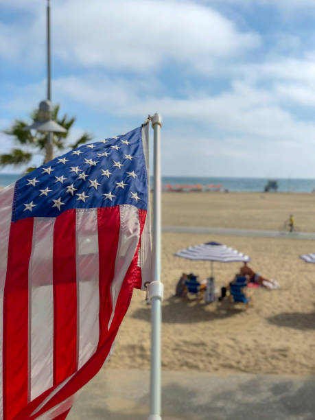 istock American flag with the beach on the background 1162889929