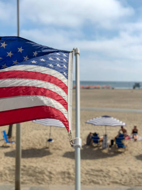 istock American flag with the beach on the background 1162890014