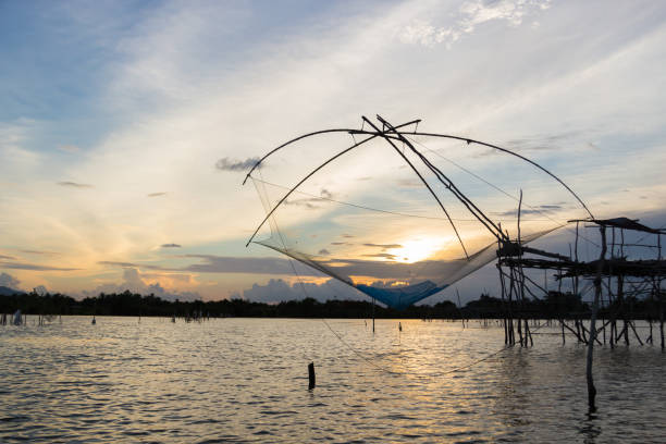 istock Silhouette of square dip nets with sunrise sky background 1162892766