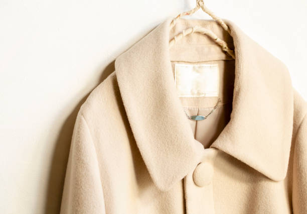 istock beige wool coat hanging on clothes hanger on white background 1162895039