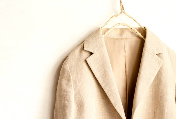 istock beige jacket hanging on clothes hanger on white background.close up. 1162895777