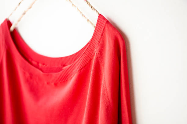 istock a cut sew or knit in red hanging on clothes hanger on white background. 1162895811