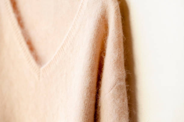 istock light pink sweater hanging on clothes hanger on white background. 1162895857