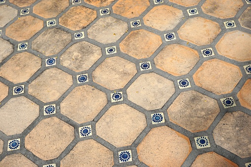 Dirty old tile floor with crooked grid of vintage square ceramic tiles in American Southwest