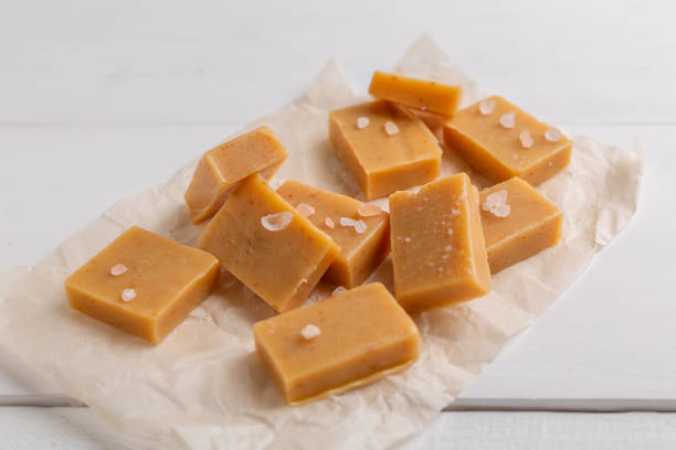 istock Fresh caramel fudge candies on white rustic background 1162898838