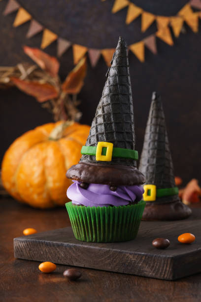 istock Funny monster cupcake with whipped cream and wafer witch hat. 1162899567