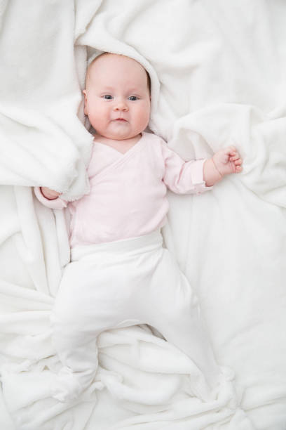 istock baby girl is lying on white blanket 1162902103