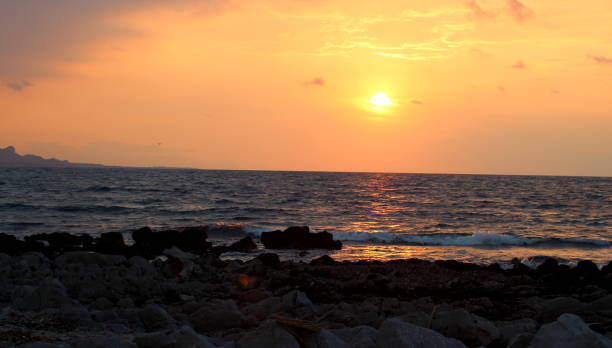 istock sunset over the sea with promontory in the background 1162904429