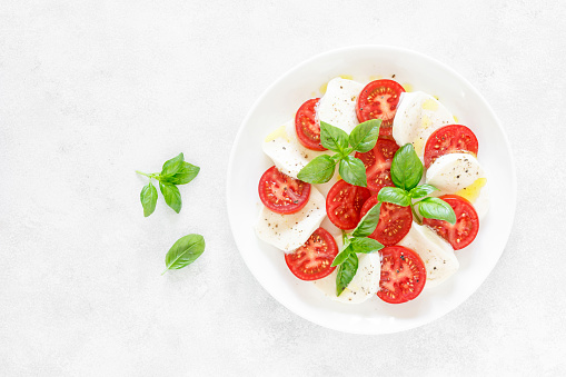 Fresh italian Caprese salad on white plate, view from above