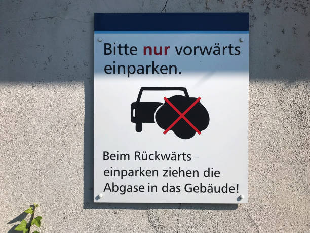 istock Warning sign: Please only park forward to prevent exhaust gas from flowing into the building (in German language) 1162906603