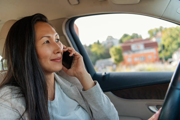 istock Smiling businesswoman using mobile phone in the car 1162910269