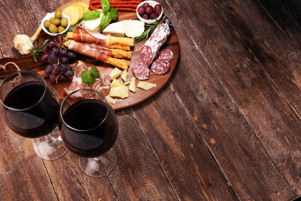 istock antipasto various appetizer. Cutting board with prosciutto, salami, cheese, bread and olives on dark wooden background 1162911218