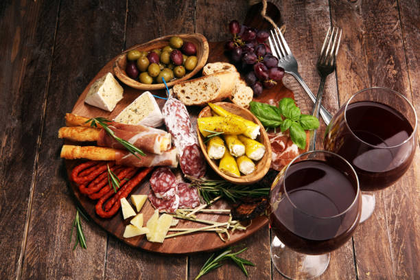 istock antipasto various appetizer. Cutting board with prosciutto, salami, cheese, bread and olives on dark wooden background 1162911241