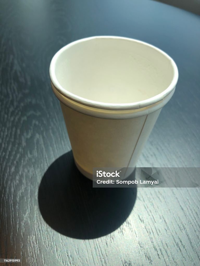 Glass Of Paper That Has Been Used And Stacked With 2 Coffee Cups Placed On  A Black Wooden Table Paper Glass Can Be Biodegradable Friendly To The  Environment And Animals Stock Photo -