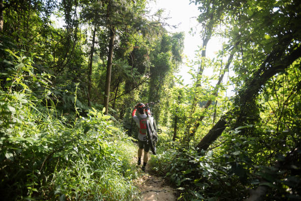 istock Woman cyclist carry a mountain walking on tropical forest 1162923348