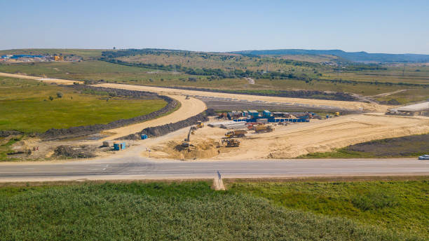 istock Aerial Road Building Site. Flight Over Construction Crews And Heavy Equipment 1162924305