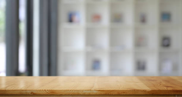 istock Empty wooden table top with Blur bookshelves in library 1162926974