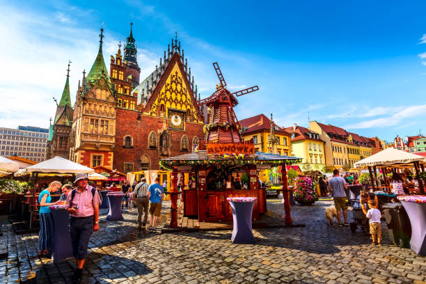 Wroclaw, Poland - June 21, 2019: Old Town Hall and decorative windmill at Market Square, stalls with food and drinks, people