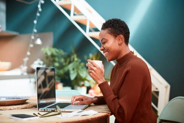 femme travaillant sur ses finances à la maison, remplissant des formulaires d'impôt. - home buisness photos et images de collection